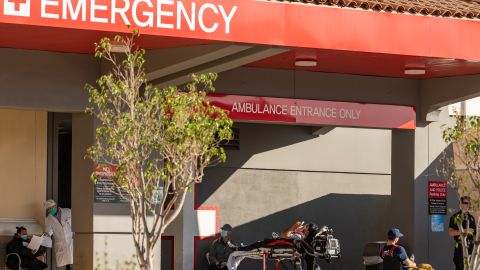 FILE - In this Dec. 18, 2020 file photo an unidentified patient receives oxygen on a stretcher, while Los Angeles Fire Department Paramedics monitor him outside the Emergency entrance, waiting for admission at the CHA Hollywood Presbyterian Medical Center in Los Angeles. After months spent tamping down surges and keeping the coronavirus at manageable levels, a variety of factors combined to bring California to a crisis point in the pandemic. (AP Photo/Damian Dovarganes,File)