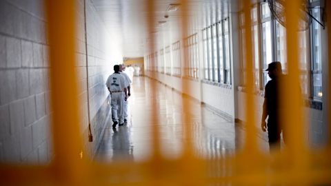 FILE - In this March 3, 2011 file photo, a guard looks on, at right, as prisoners move through the state prison in Jackson, Ga. After years of middling progress, Georgia lawmakers could soon adopt reforms to overhaul the state's clogged, and expensive, prison system. (AP Photo/David Goldman, File)